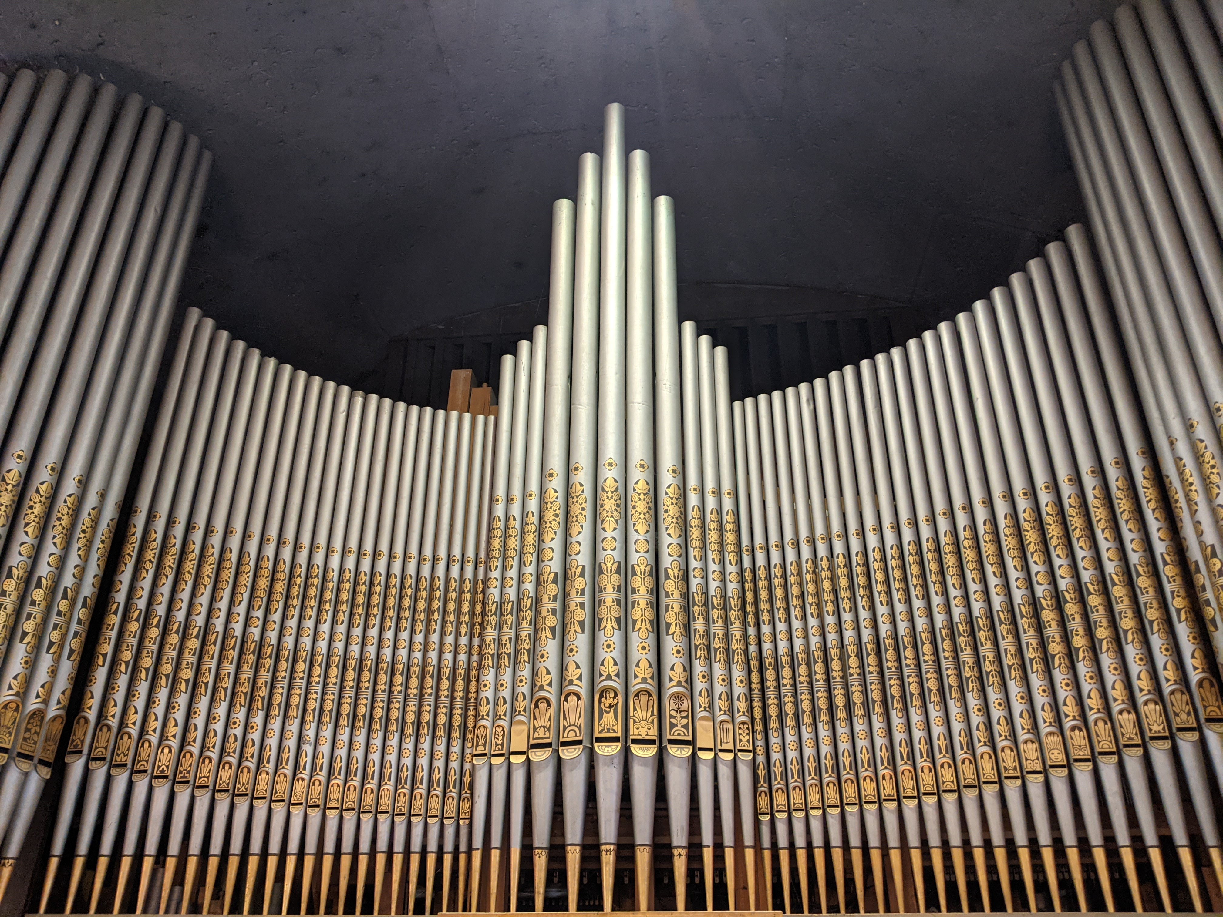 Große, verzierte Kirchenorgelpfeifen mit Goldverzierung.